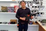 Man holds a gel blaster in a shop