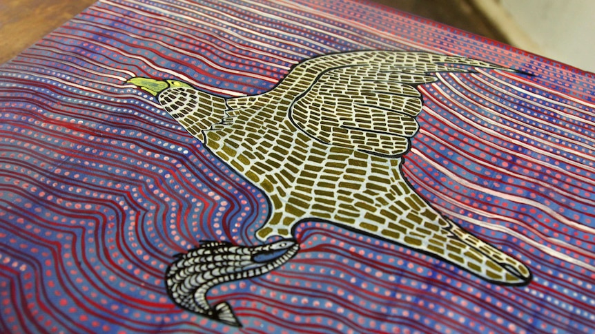 A dot-painting style artwork depicting an eagle flying with a barramundi.