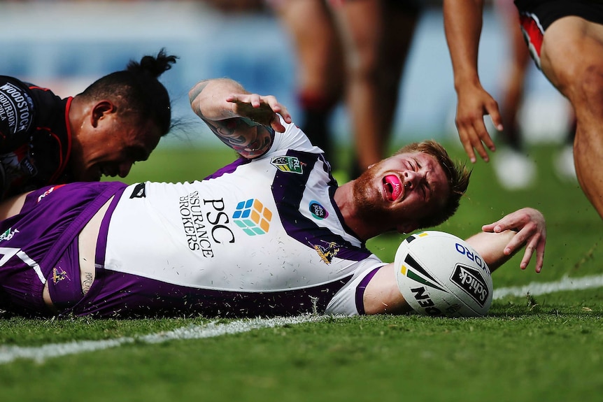 Cameron Munster of the Storm scores a try against Solomone Kata of the Warriors