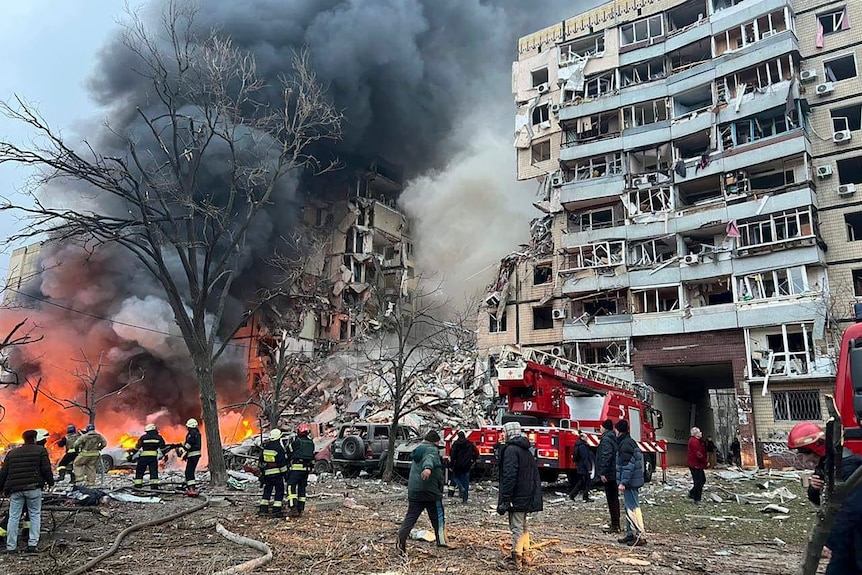 Firefighters at the scene of a fire at a multi-storey building in Dnipro.