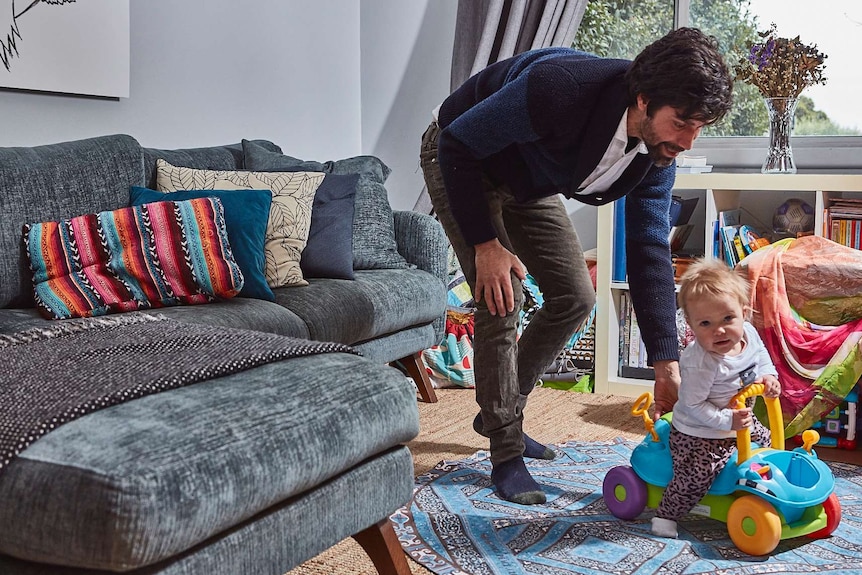 Brett Lee helps his daughter play with a toy car.