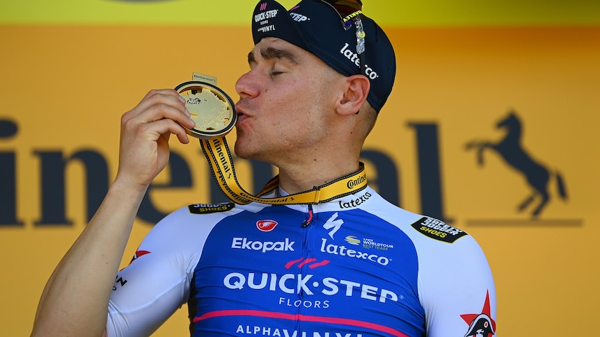 A man kisses his medal in celebration