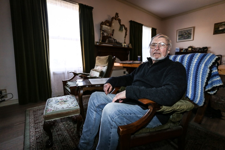 Bruce Riddler sitting on his armchair at home.