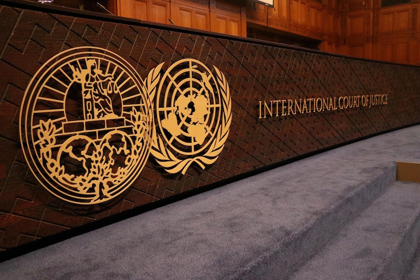 Simbol mare auriu cu două cercuri inscripționate lângă Curtea Internațională de Justiție, scrise cu majuscule