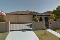 a house with cream render and a fence