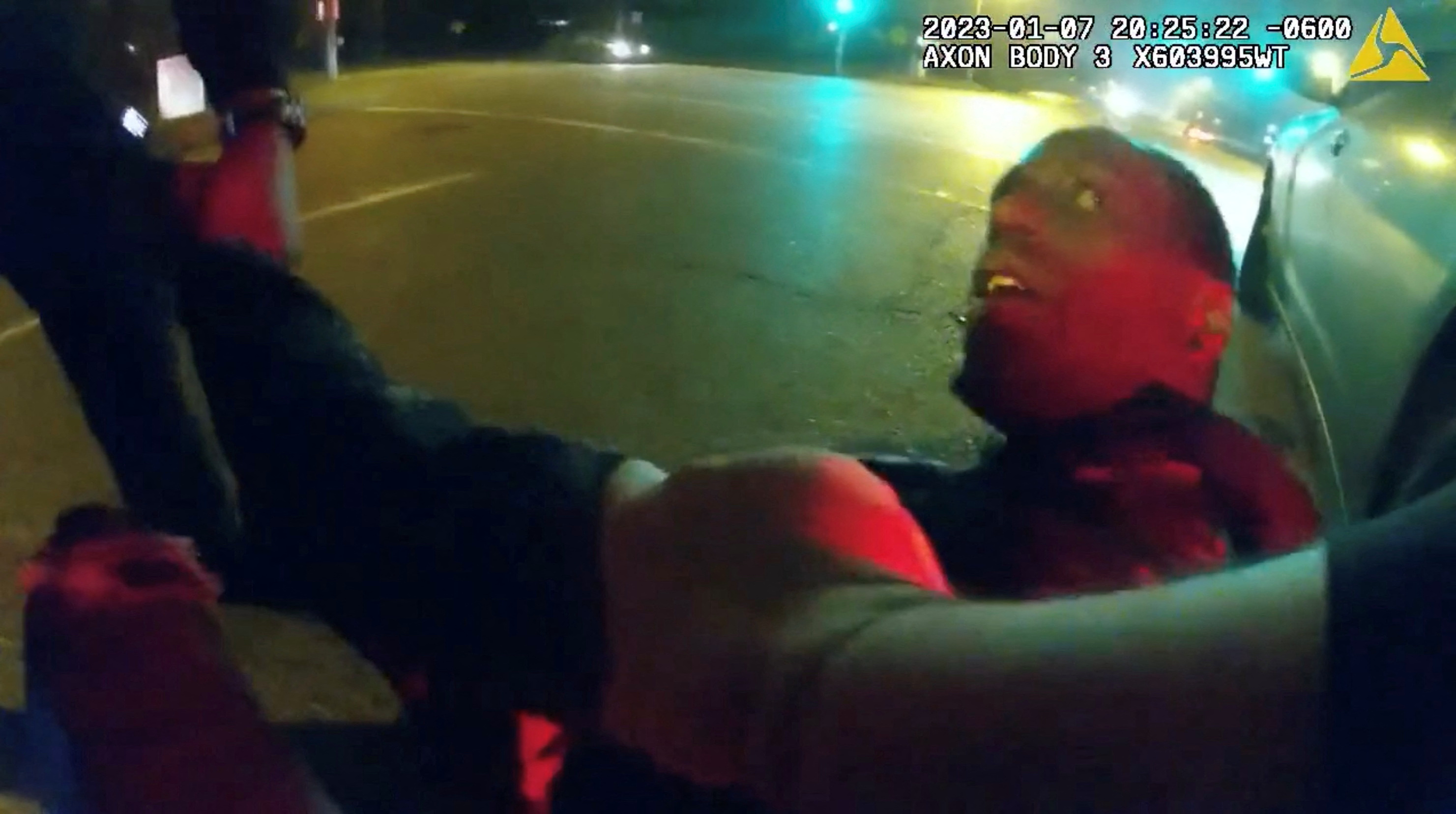 截图显示一名年轻的黑人男子在被暴力逮捕时抬头看着警察。