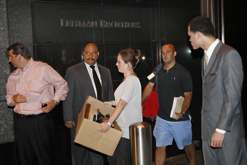 Five people, two of them security guards, in front of Lehman Brothers building in 2008. Three are carrying boxes and documents.