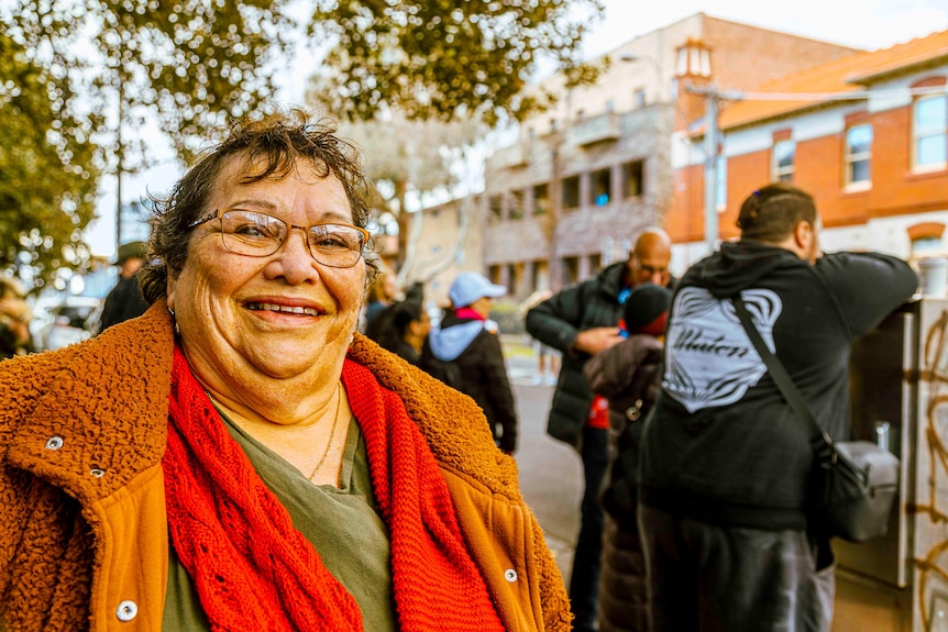 Judith Jackson smiling widely and wearing a bright red scarf.