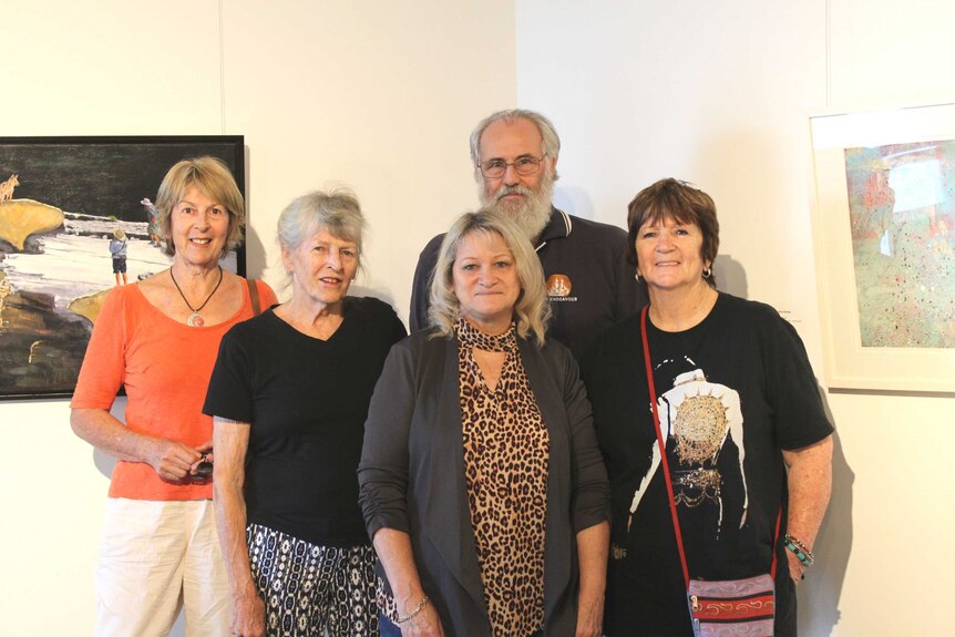 Five artists stand in Hervey Bay Regional Art Gallery