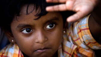 A young Sri Lankan girl looks up as asylum seekers engage in a hunger strike, at Cilegon on October 16, 2009 in Merak, Java, ...