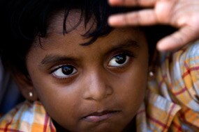 A young girl looks up as Sri Lankan asylum seekers engage in a hunger strike after their boat broke down on the way to Austra...