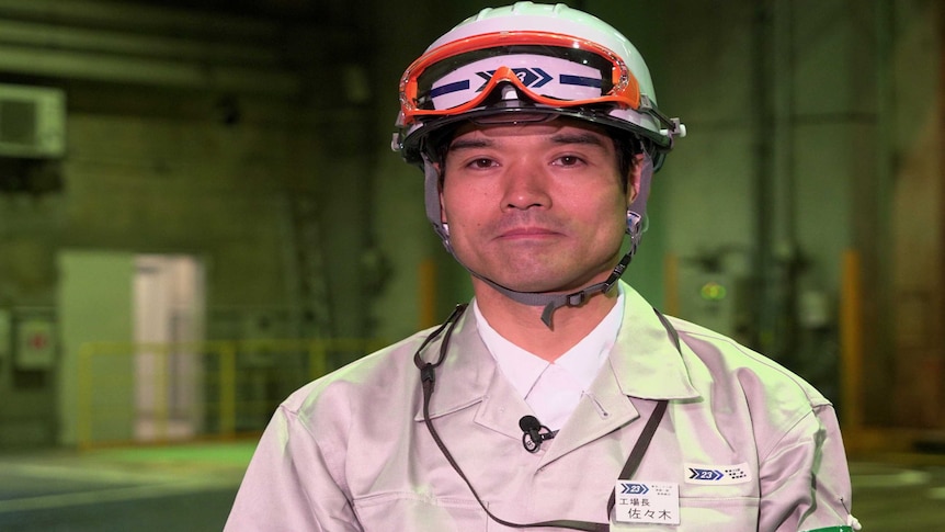 An image of a Japanese man in an industrial plant wearing a hard hart
