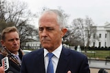 Malcolm Turnbull stands in front of a press pack.