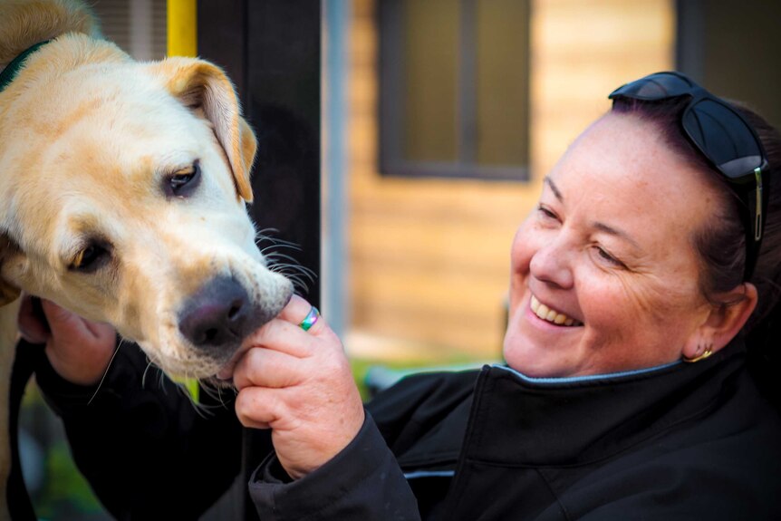 NSW Guide Dogs dog handler Kerry Chauncy patting labrador puppy at Frank Baxter Juvenile Detention Centre. June 11, 2018.