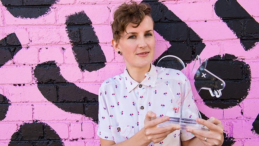 A woman holds an award.