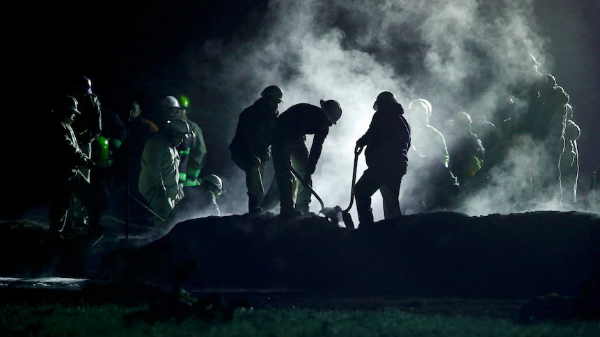 Staff of Pemex, Petroleos Mexicanos, works the area of a oil pipeline explosion.