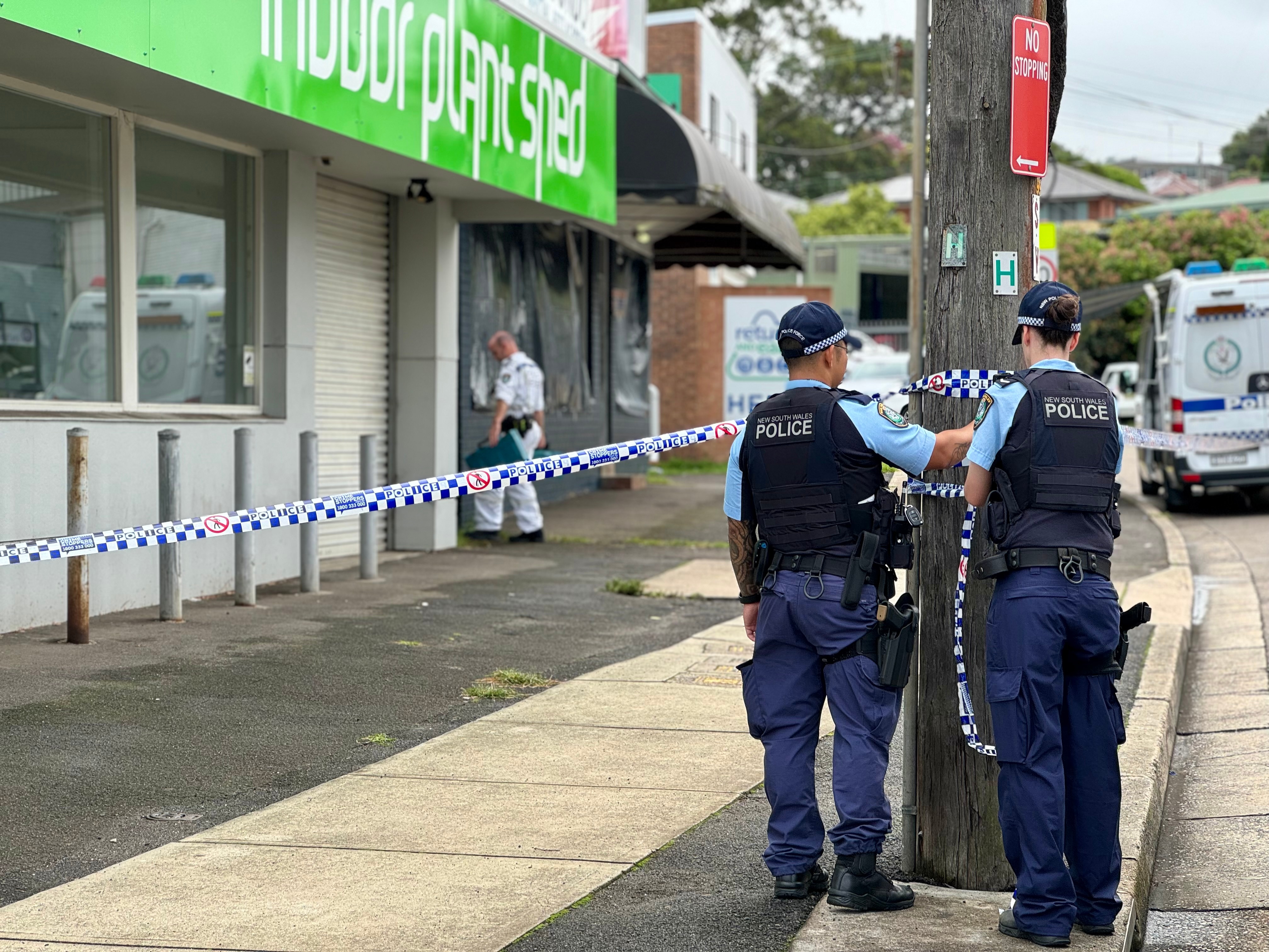 Two police officers tape off a crime scene