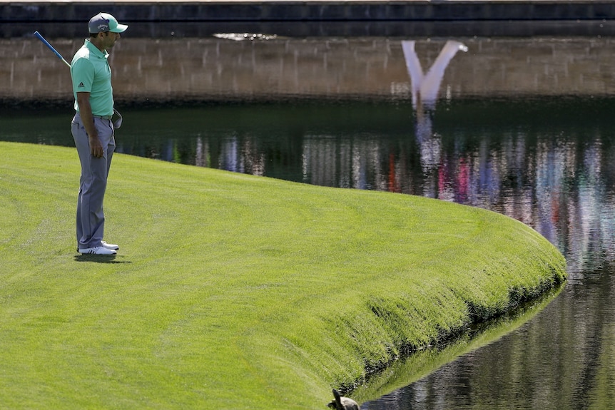 Spanish golfer Sergio Garcia looks into the pond after hitting the ball in the water