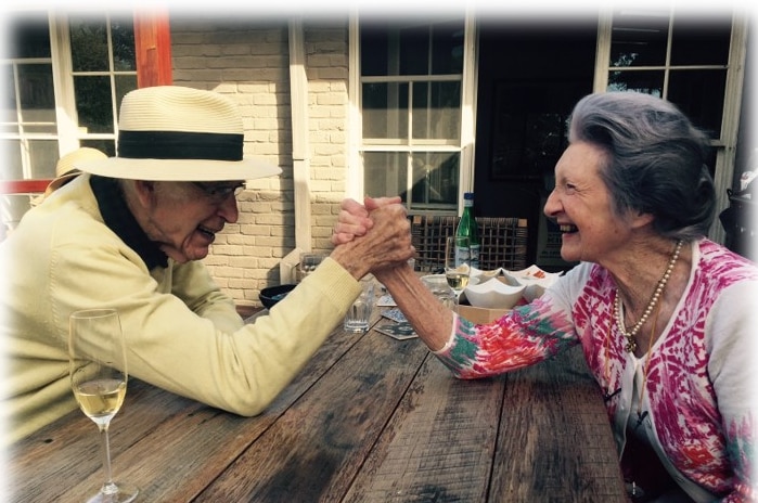 Elderly man and woman doing an arm wrestle.