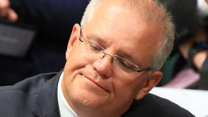 Scott Morrison leans back in his chair with a serious expression on his face