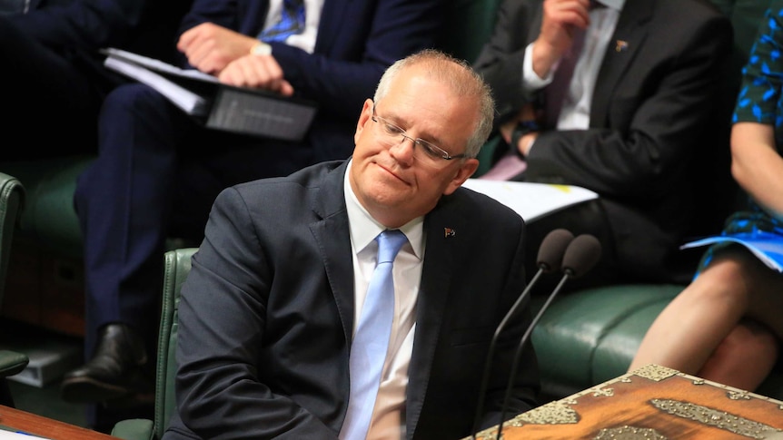 Scott Morrison leans back in his chair with a serious expression on his face