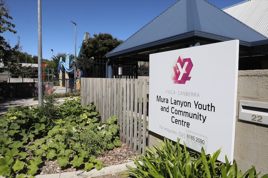A YMCA sign outside a Lanyon building showing the location of the teen clinic