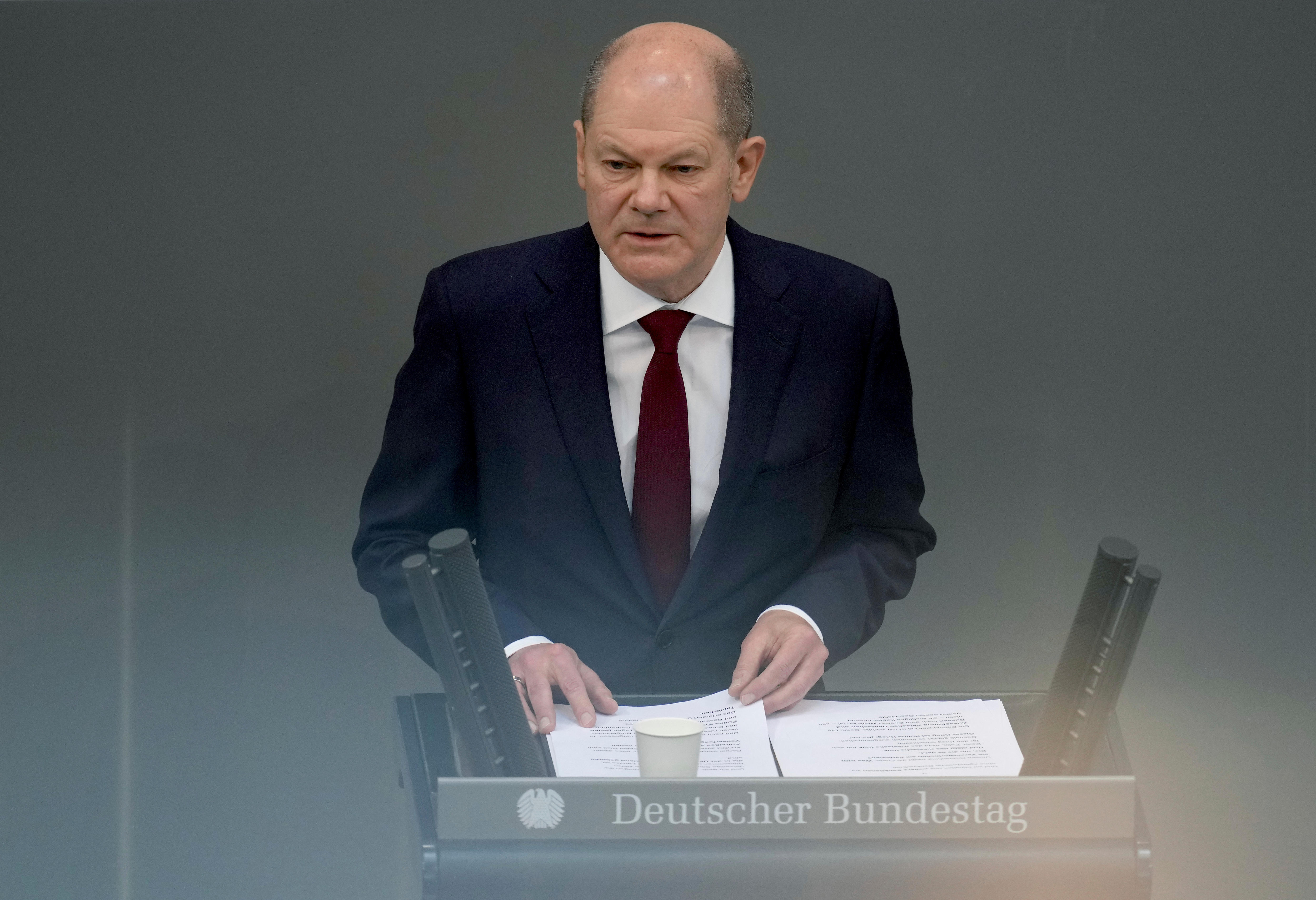 German Chancellor Olaf Scholz delivers a speech at a lectern.