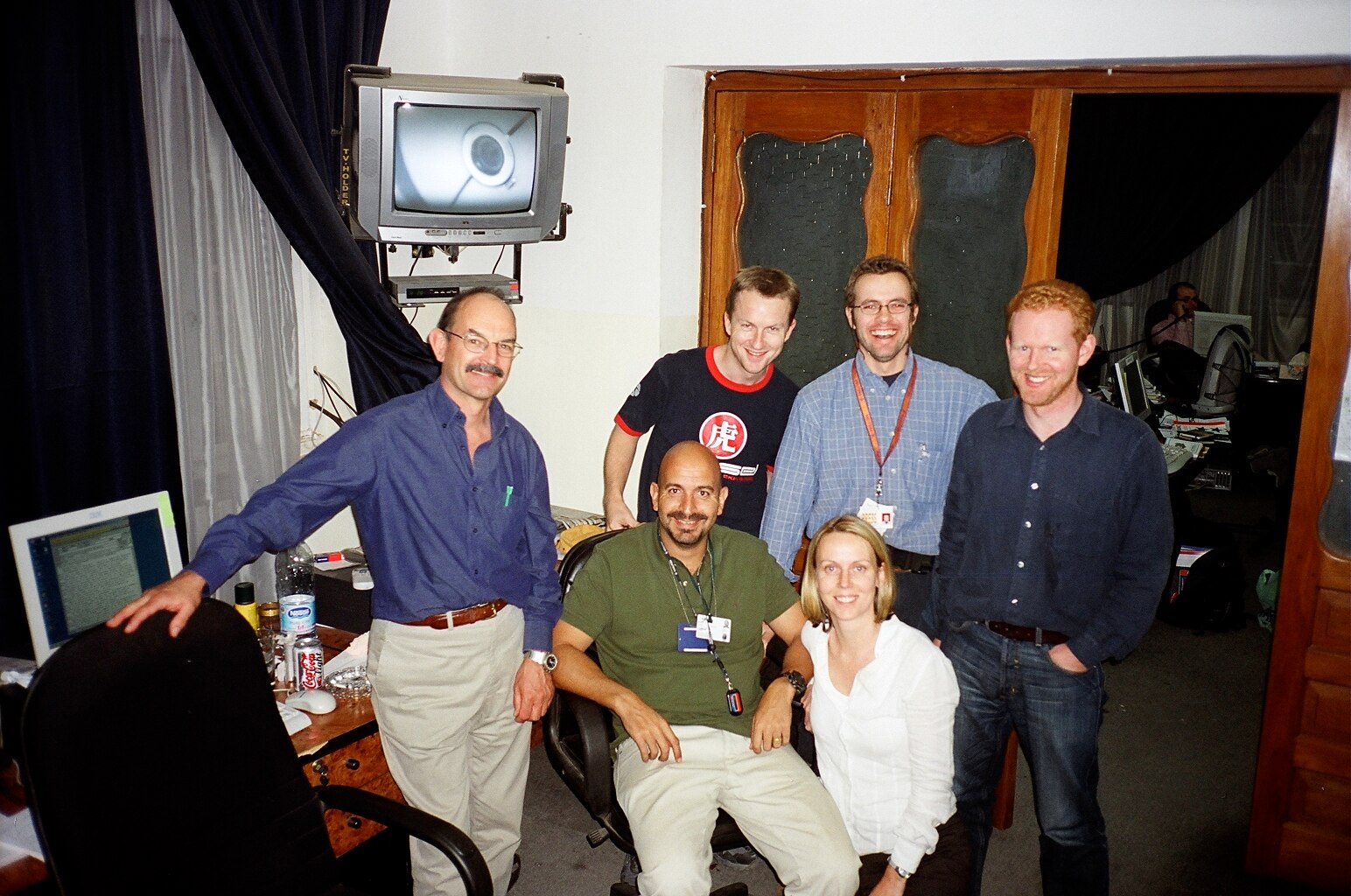 A group photo of colleagues in an office setting consisting of five men and one woman