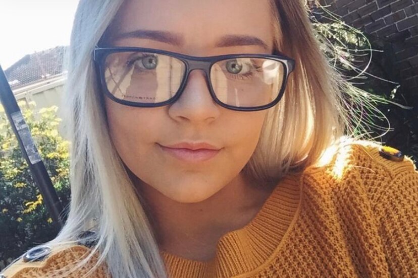 A woman with glasses takes a selfie