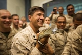 A group of Marine hold a baby crocodile