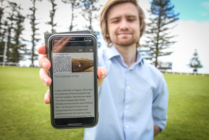 Joseph Edwards holds a smartphone with the walking app on it.