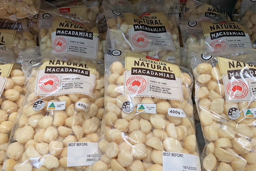 Packets of macadamias on supermarket shelf.