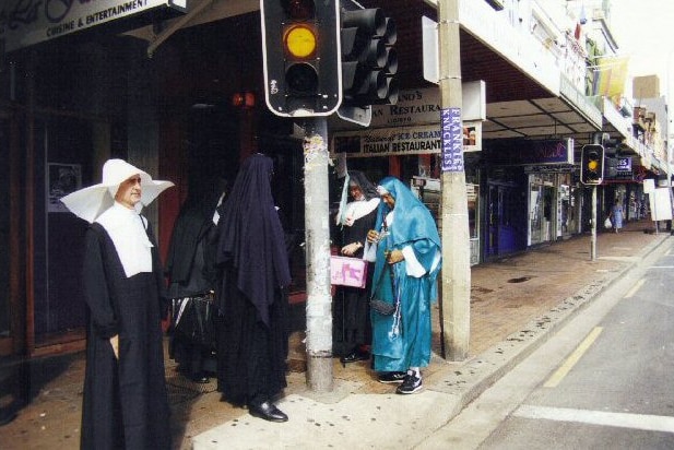 A man dressed in a red nun's costume and a drag queen