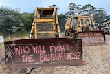 Two logging machines have been graffitied with the words "who will fight the bushfires?"