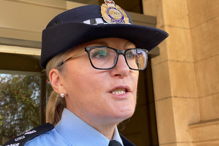 Close up of a woman wearing an AFP hat and black square glasses