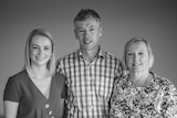 Black and white photo of a smiling mother, father and daughter.