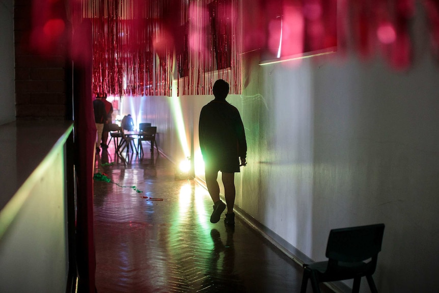 A student walks through a hall covered in tinsel.
