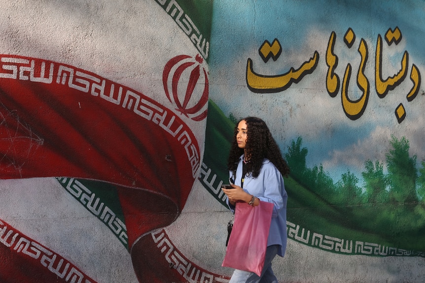 a young woman walks pasta flag of the Islamic Republic of Iran
