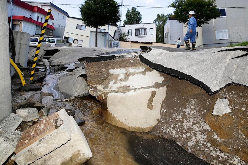 There is a pit in the road big enough to swallow a small car, with cracked tarmac at odd angles lying on the edges