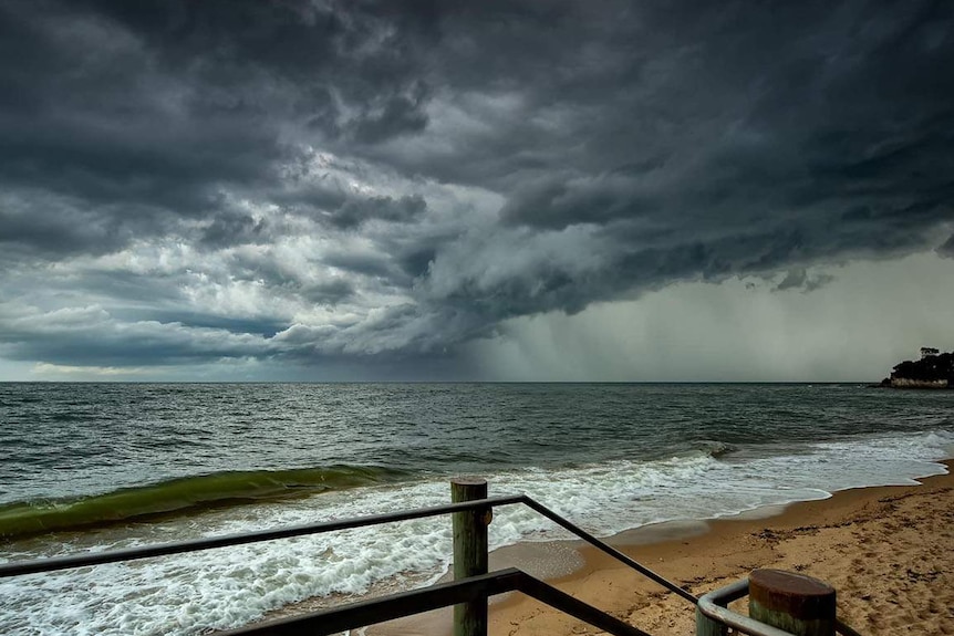 Storm clouds and rain coming in from the sea off a beach at Redcliffe.