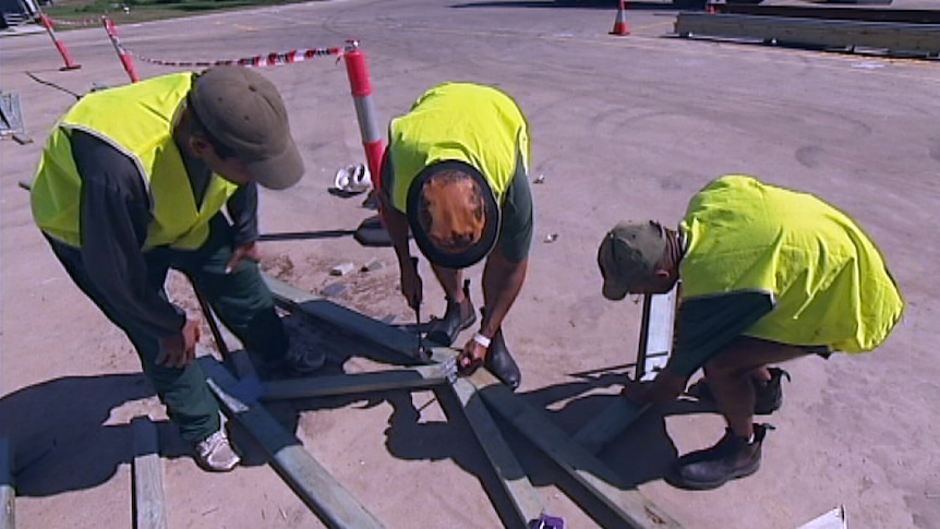 Indigenous inmates work building a house