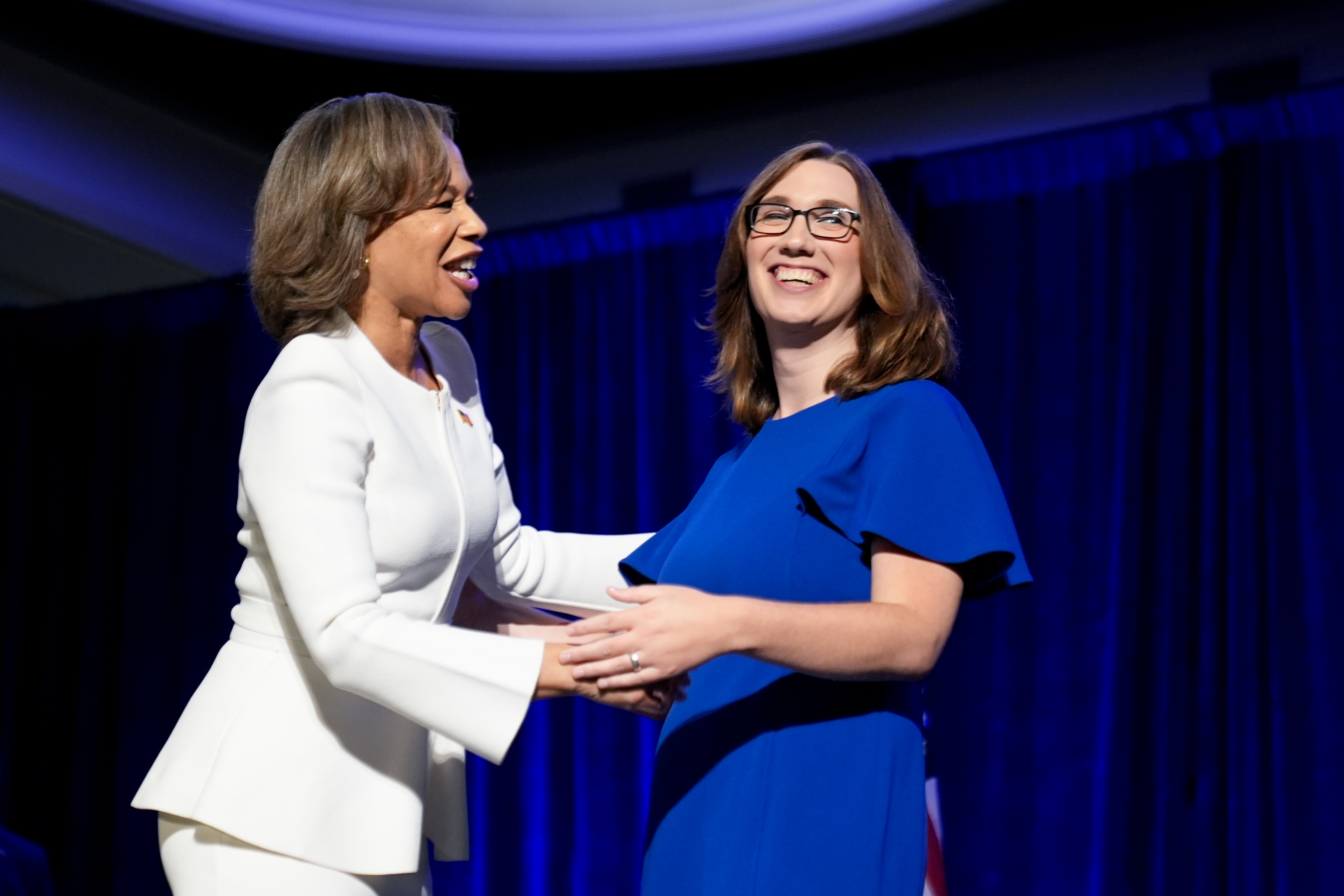 Two people embracing on stage during US election day