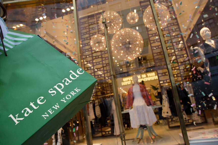 A woman carries her Kate Spade shopping bag outside the fashion designer's Madison Avenue store.