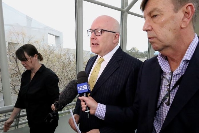 Attorney-General walking and being interviewed by journalists