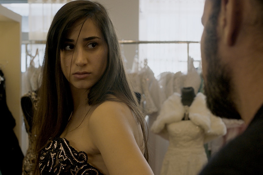 Colour still of Maria Zreik in a wedding dress boutique in 2017 film Wajib.