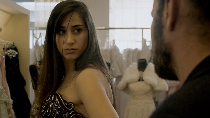 Colour still of Maria Zreik in a wedding dress boutique in 2017 film Wajib.
