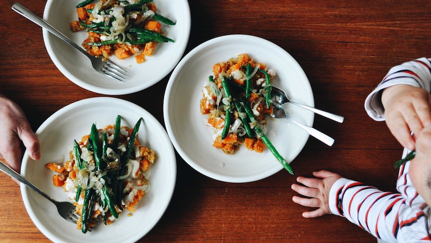 Three bowls filled with quinoa, sweet potato and beans, cooked in a single pot, a healthy family dinner recipe.