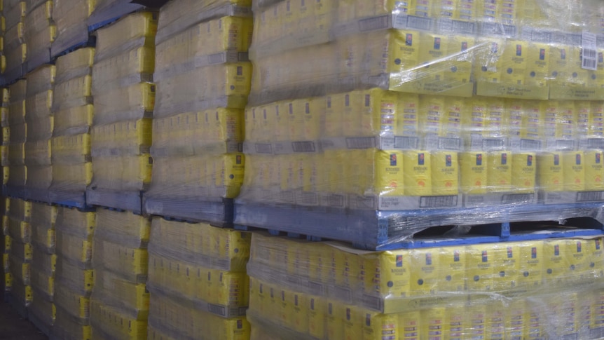 Pallets of Bundaberg Sugar product are lined up in a storehouse ready to be transported to stores.