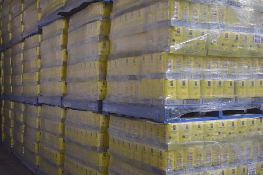 Pallets of Bundaberg Sugar product are lined up in a storehouse ready to be transported to stores.