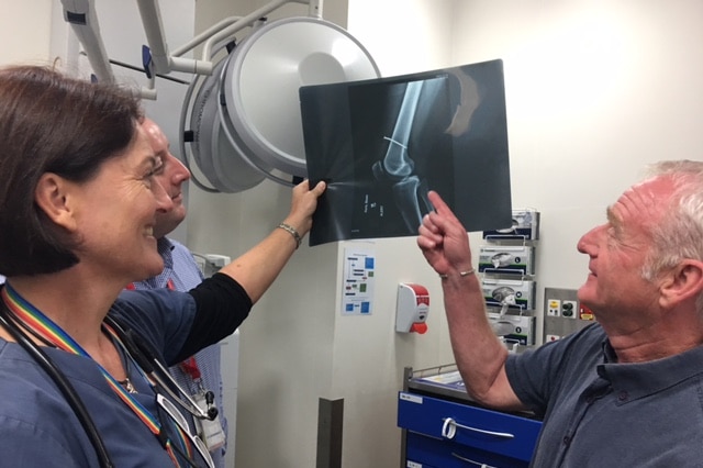 Dr Eley (right) examines a nail gun injury to a thigh, at the PA Hospital.